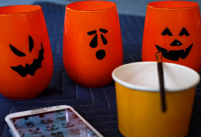 finished painting faces on the Jack-O-Lantern candle holders