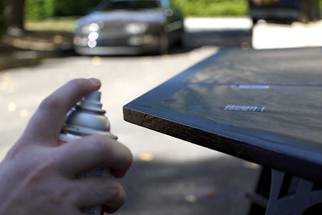 spraying Rustoleum truck bed coating on edges of desk top